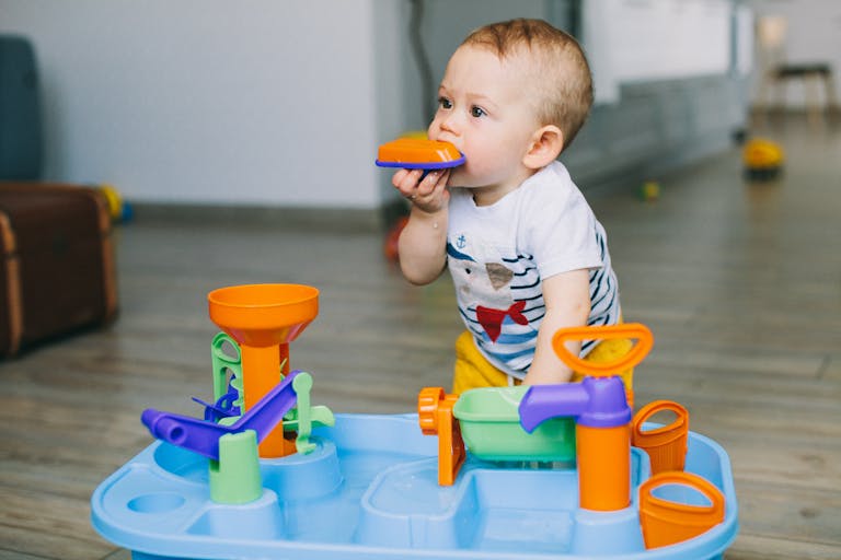 Baby Boy Biting an Orange Toy