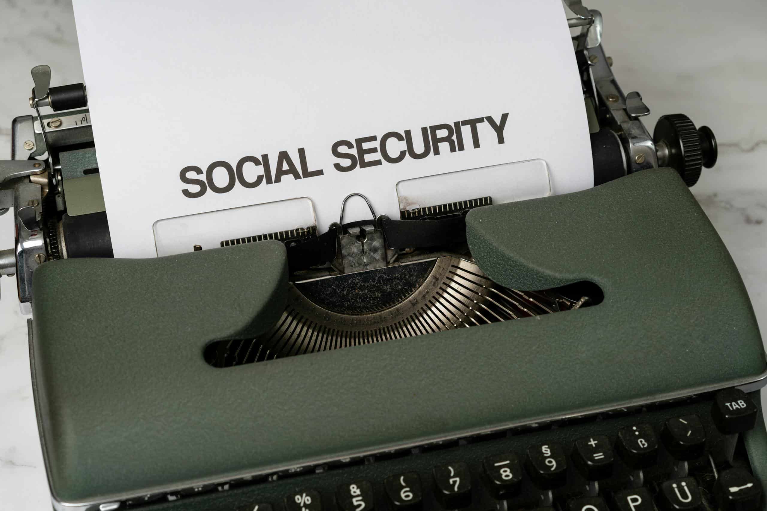 Close-up of a vintage typewriter typing 'SOCIAL SECURITY' on paper.