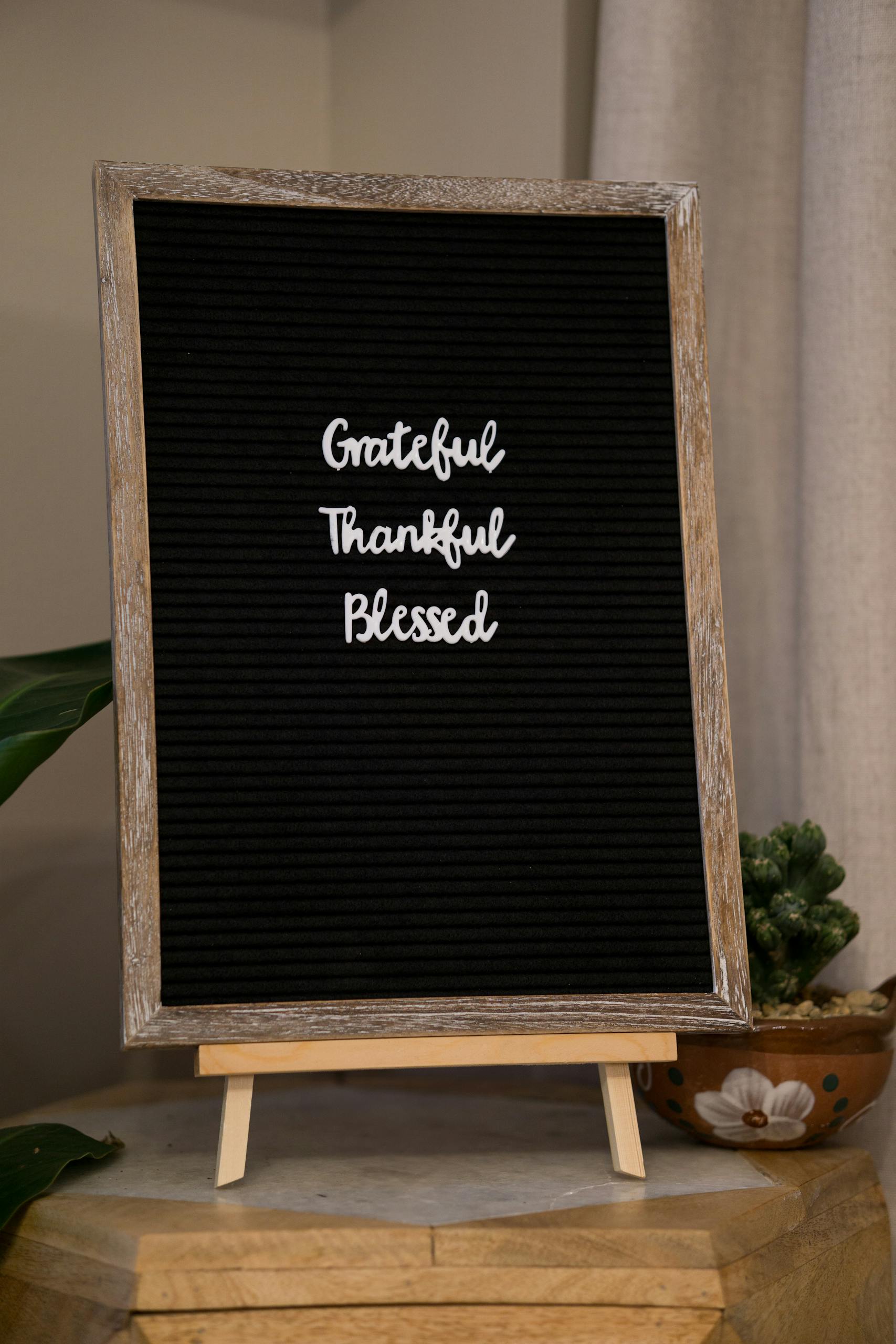Blackboard featuring the words 'Grateful Thankful Blessed' in a cozy interior setting.