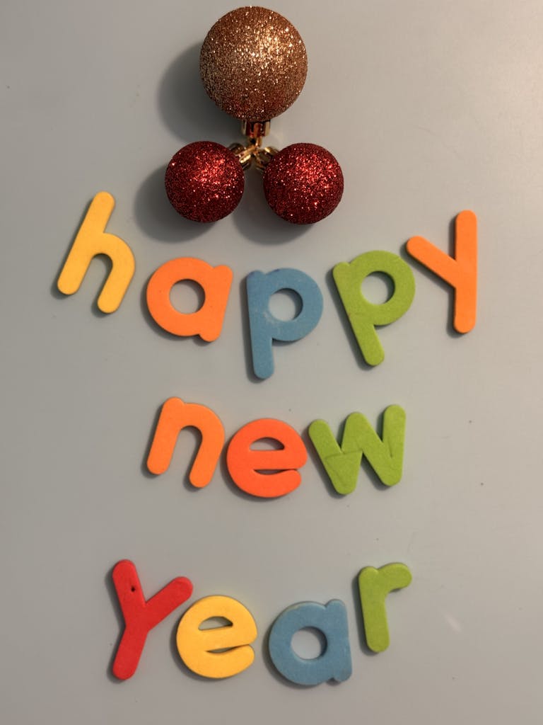 Vibrant New Year message with colorful letters and festive ornaments.